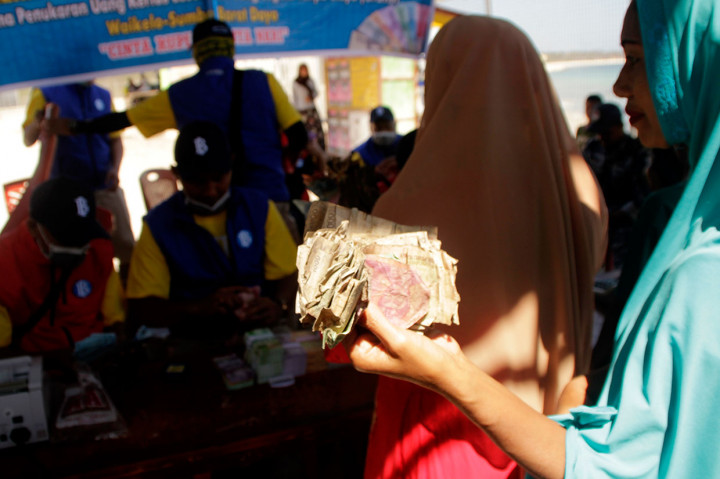 Seorang warga antre untuk menukarkan pecahan uang rupiah yang sudah lusuh saat pelaksanaan ekspedisi kas keliling Bank Indonesia ke pulau-pulau terluar, terdepan dan terpencil (3T) di Desa Waikelo, Kabupaten Sumba Barat Daya, NTT, Sabtu, 21 September 2019. 