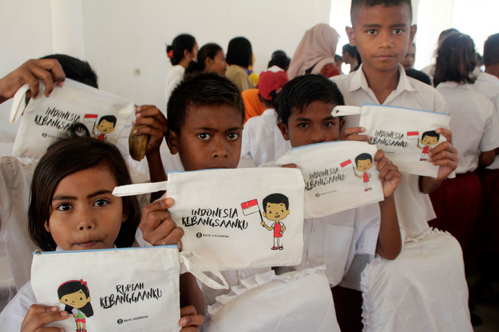 Sejumlah pelajar menunjukkan dompet bertuliskan 'Rupiah Kebanggaanku' ketika disosialisasikannya ciri-ciri keaslian uang Rupiah di Desa Waikelo, Kabupaten Sumba Barat Daya, NTT.