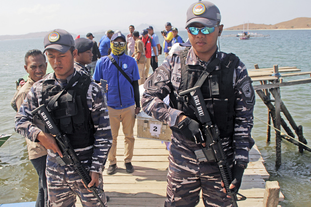 Pasukan TNI AL bersenjata lengkap mengawal petugas yang membawa kotak berisi uang Rupiah ke desa Komodo untuk melaksanakan penukaran uang lusuh dalam kegiatan Ekspedisi Kas Keliling pulau Terluar, Terdepan dan Tertinggal (3T) hari kedua di Pulau Komodo, Kabupaten Manggarai Barat, NTT.