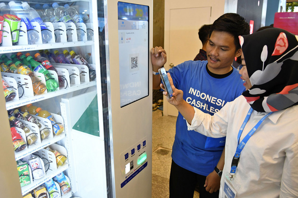 Petugas mengarahkan calon pelanggan untuk mengaktifkan salah satu produk 'fintech' pada Indonesia Fintech Summit & Expo 2019 di Jakarta Convention Center (JCC), Jakarta.


