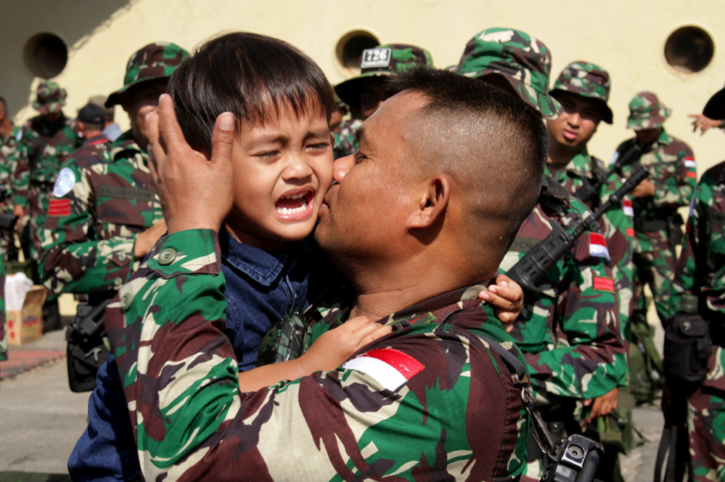 Seorang prajurit TNI mencium anaknya sebelum pemberangkatan pasukan Satuan Tugas (Satgas) Yonif 726/Tml di Pelabuhan Soekarno Hatta, Makassar, Sulawesi Selatan, Selasa, 24 September 2019.