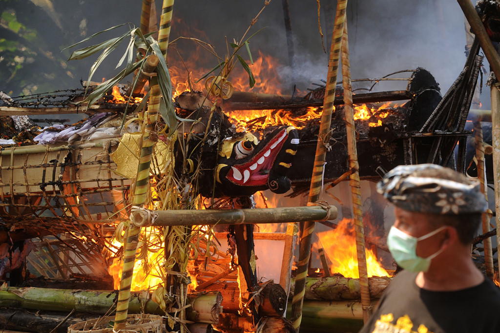 Warga menyaksikan kremasi bagi anggota keluarganya dalam upacara Ngaben massal di Desa Adat Bayad, Tegalalang, Gianyar, Bali.