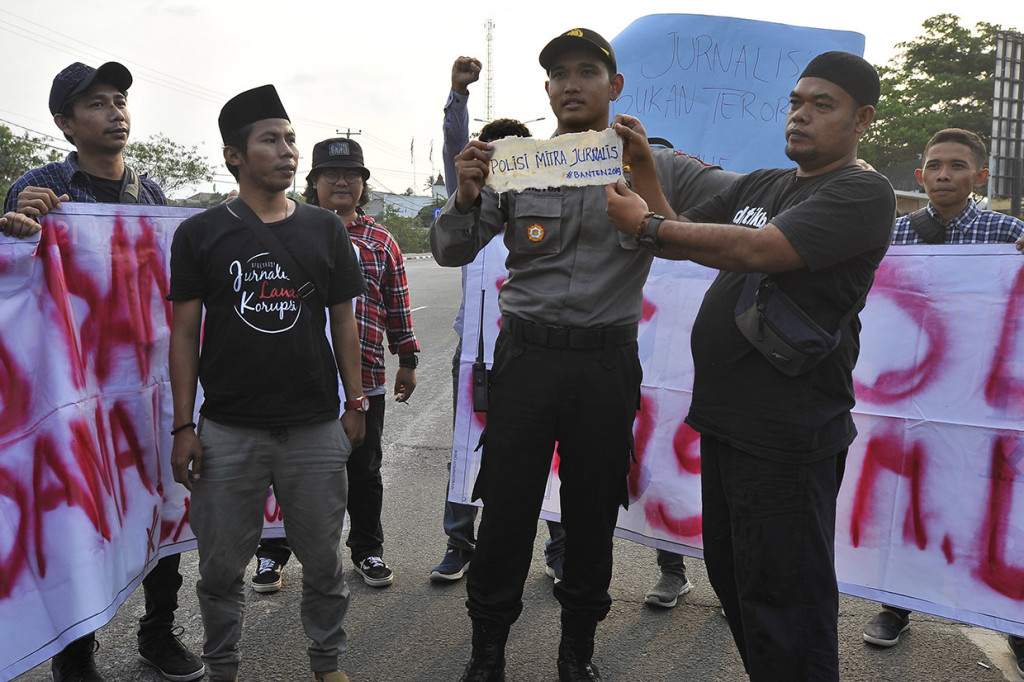 Sejumlah wartawan yang tergabung dalam Wartawan Banten Cinta Damai menyerahkan pernyataan sikap kepada anggota Polri saat berunjuk rasa di Puspemprov Banten, di Serang, Banten.