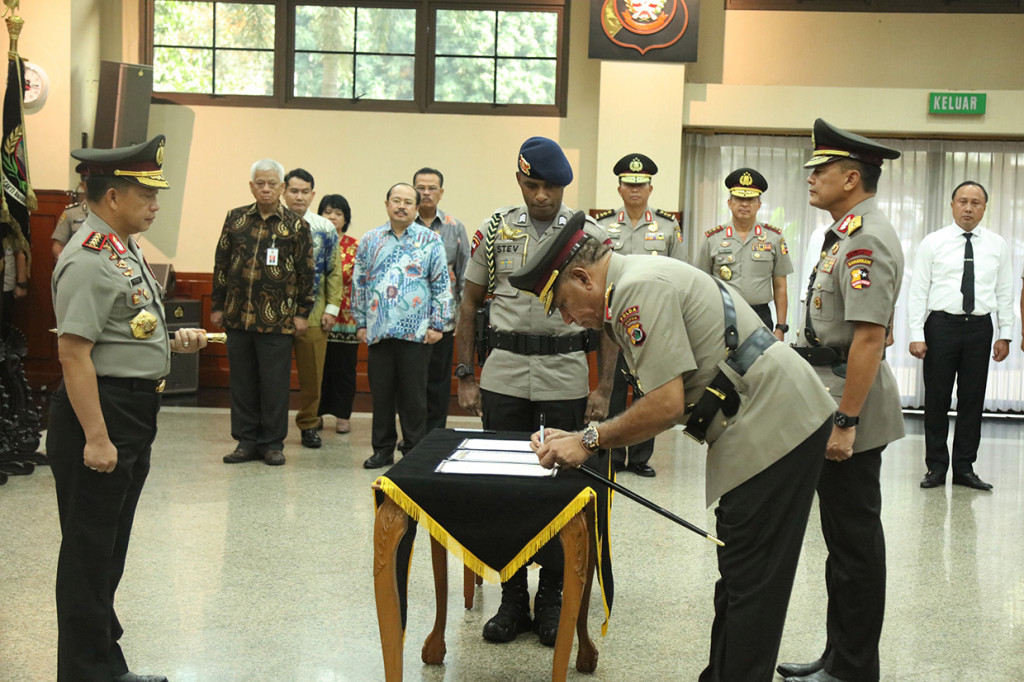 Kapolri Jenderal Pol Tito Karnavian (kiri) menyaksikan Kapolda Papua Irjen Pol Paulus Waterpauw (tengah) membubuhkan tanda tangan disaksikan pejabat lama Irjen Pol Rudolf Albert Rodja saat upacara sertijab di Mabes Polri, Jakarta.