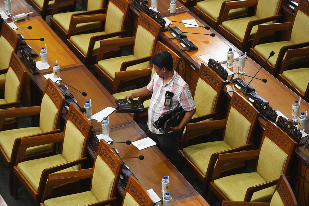 Seorang petugas mengumpulkan papan nama anggota DPR usai Sidang Paripurna terakhir DPR periode 2014-2019 di Kompleks Parlemen, Senayan, Jakarta.