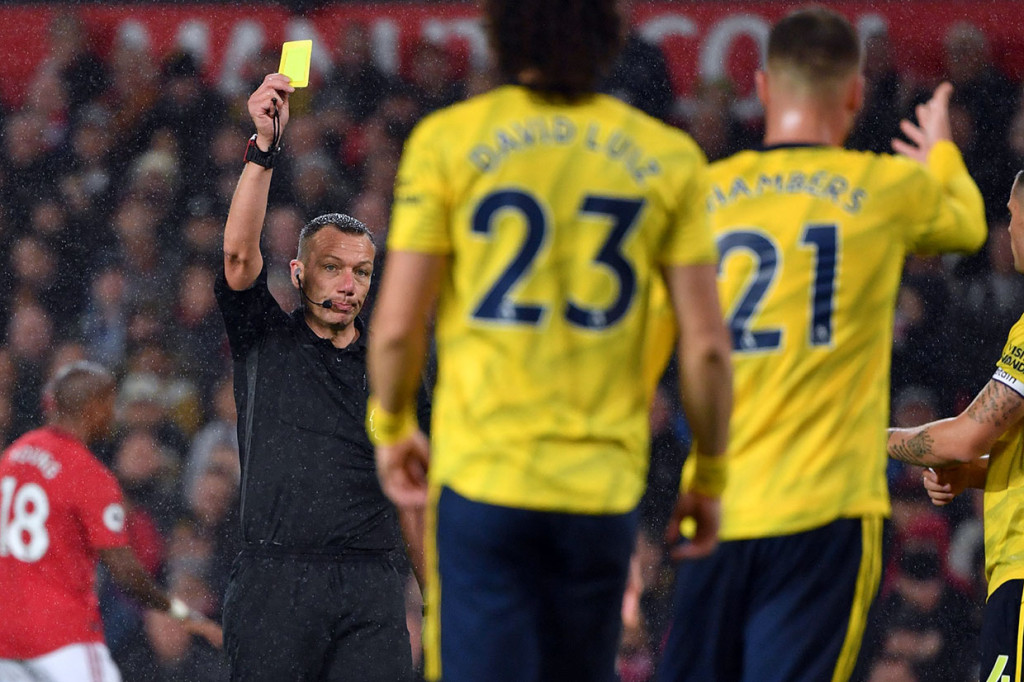 Pemain Arsenal Calum Chambers diganjar kartu kuning oleh wasit karena melanggar pemain lawan.