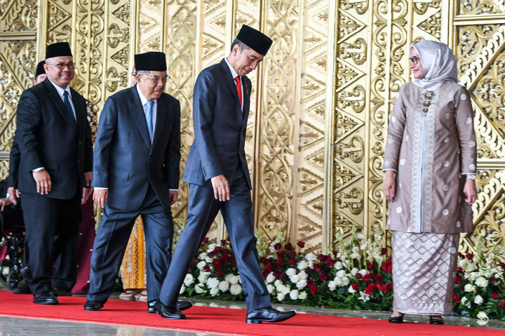 Ibu Negara Iriana Joko Widodo bersama Ibu Mufidah Jusuf Kalla melambaikan tangan kepada wartawan saat menghadiri pelantikan anggota DPR RI di Kompleks Parlemen, Senayan, Jakarta.