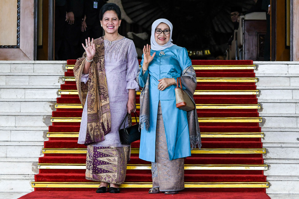 Ibu Negara Iriana Joko Widodo bersama Ibu Mufidah Jusuf Kalla melambaikan tangan kepada wartawan saat menghadiri pelantikan anggota DPR RI di Kompleks Parlemen, Senayan, Jakarta.