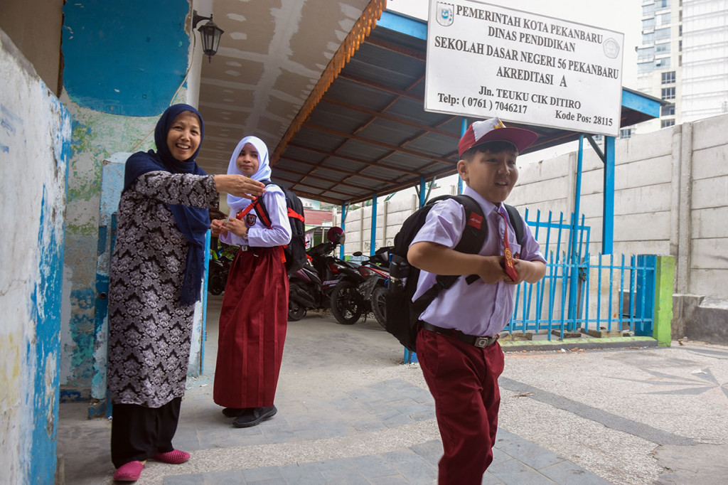 Seorang pencari suaka asal Pakistan menjemput anaknya pada hari pertama masuk sekolah di SDN 56, Kota Pekanbaru, Riau. 