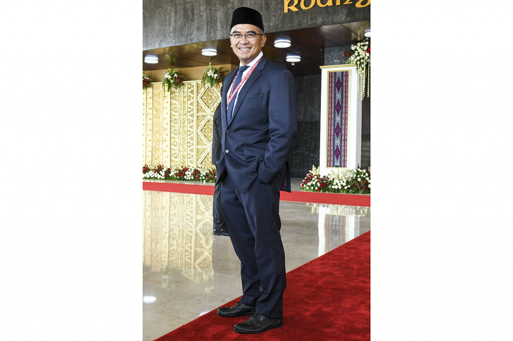 Presenter Muhammad Farhan Artis Tommy Kurniawan tampil dengan balutan jas hitam dan dasi biru dongker saat menghadiri pelantikan DPR RI. Antara Foto/Galih Pradipta