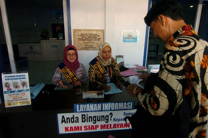 Dalam rangka Hari Batik Nasional, petugas polisi wanita (Polwan) berpakaian batik melayani pembuatan Surat Izin Mengemudi (SIM) di Kantor Satlantas Polres Tegal, Jawa Tengah. Antara Foto/Oky Lukmansyah