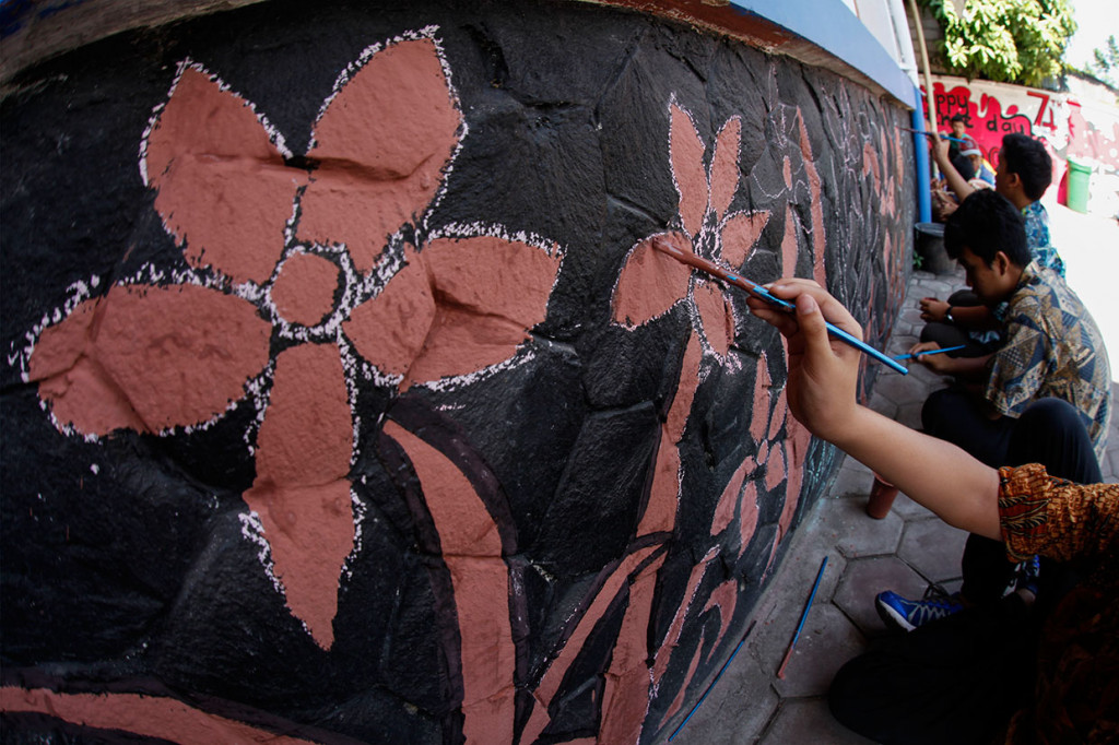 Siswa SMP Lazuardi Kamila Solo membuat mural dengan motif batik pada dinding sekolah setempat, Solo, Jawa Tengah. Mural tersebut dibuat untuk merayakan Hari Batik Nasional sekaligus sebagai kegiatan belajar luar ruang. Antara Foto/Maulana Surya