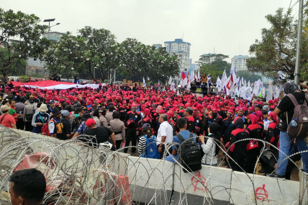 Para buruh berunjuk rasa menyampaikan aspirasinya kepada anggota DPR yang baru saja dilantik, terkait isu-isu menyangkut kesejahteraan buruh seperti tolak upah murah hingga soal tingginya iuran BPJS kesehatan.   