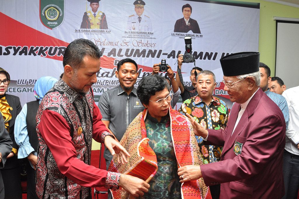 Salah satu pimpinan KPK periode 2019-2023 terpilih Lili Pintauli Siregar (tengah) dipasangkan kain ulos oleh Wakil Gubernur Sumut Musa Rajeckshah (kiri) dan Pemangku Kesultanan Deli, Gelar Tengku Raja Muda Deli, Tengku Hamdy Osman Deli Khan (kanan) saat acara Tasyakuran Pimpinan KPK Terpilih oleh Alumni Universitas Islam Sumatera Utara (UISU) di Medan, Sumatera Utara.