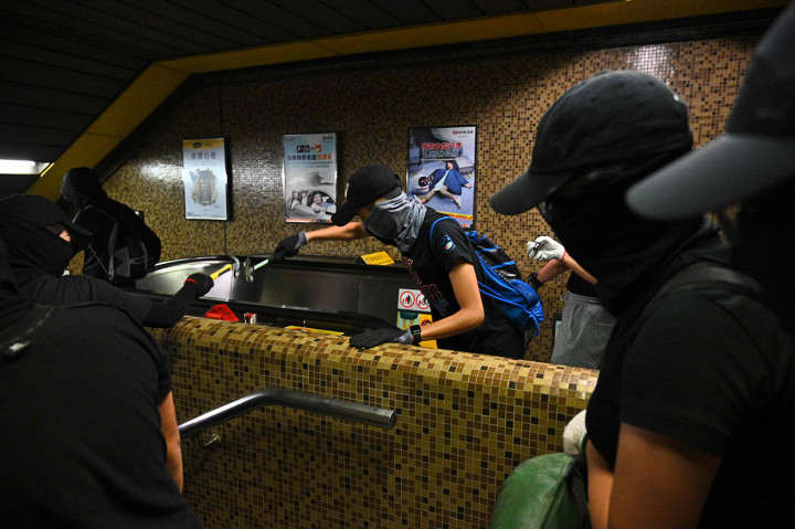 Sekelompok pemrotes bermasker menghancurkan stasiun MTR Wong Tai Sin di distrik Kowloon Hong Kong. AFP Photo/Philip Fong
