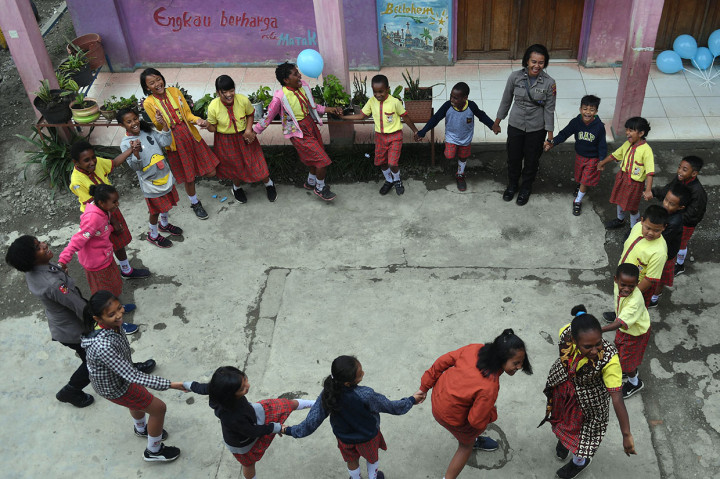 Dua orang anggota polisi wanita bermain dengan siswa SD Triesa Unggul Terpadu di Wamena, Kabupaten Jayawijaya, Papua, Rabu, 9 Oktobe 2019. 
