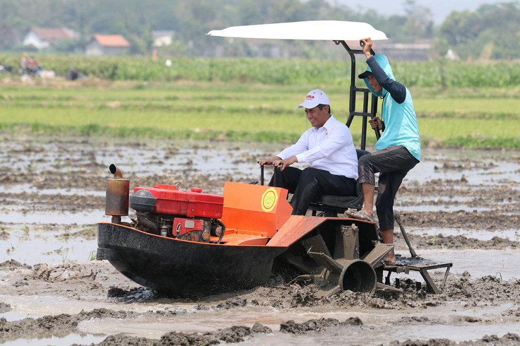 Menteri Pertanian Andi Amran Sulaiman mengendarai traktor rawa saat mendemonstrasikan mesin-mesin untuk teknologi pertanian di Desa Jabon, Kediri, Jawa Timur, Rabu, 9 Oktober 2019.