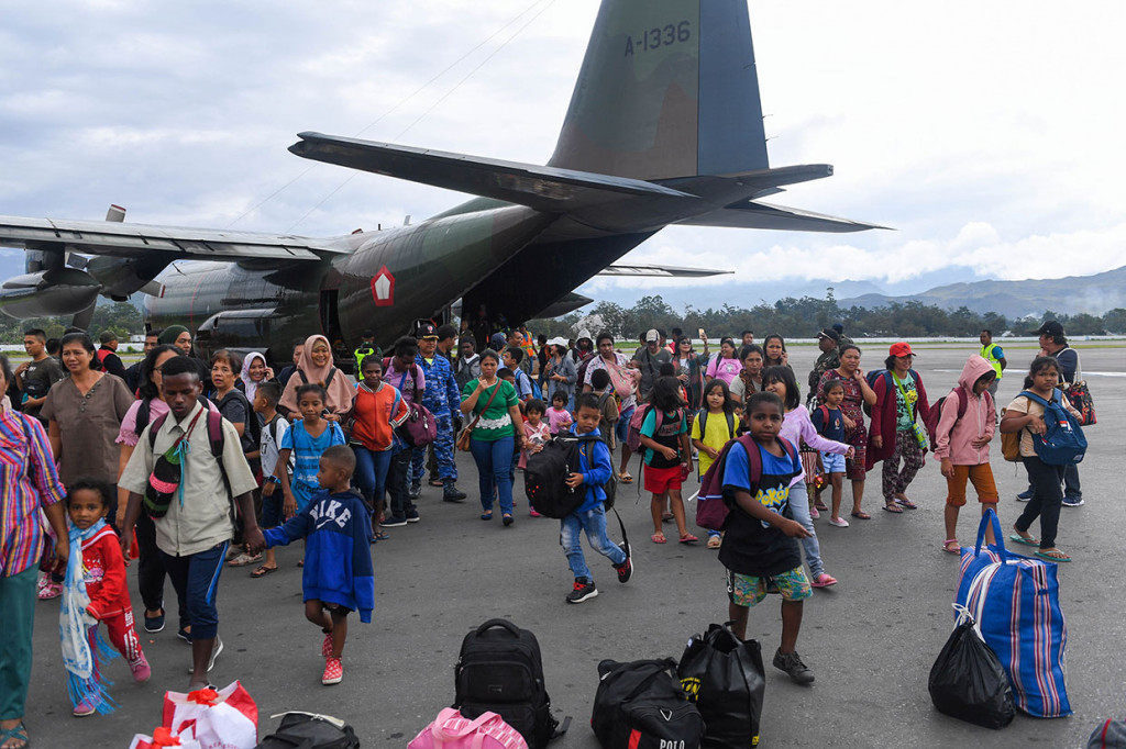 Puluhan pengungsi berjalan menuruni pesawat Hercules TNI AU saat tiba di Bandar Udara Wamena, Kabupaten Jayawijaya, Papua, Kamis, 10 Oktober 2019. 