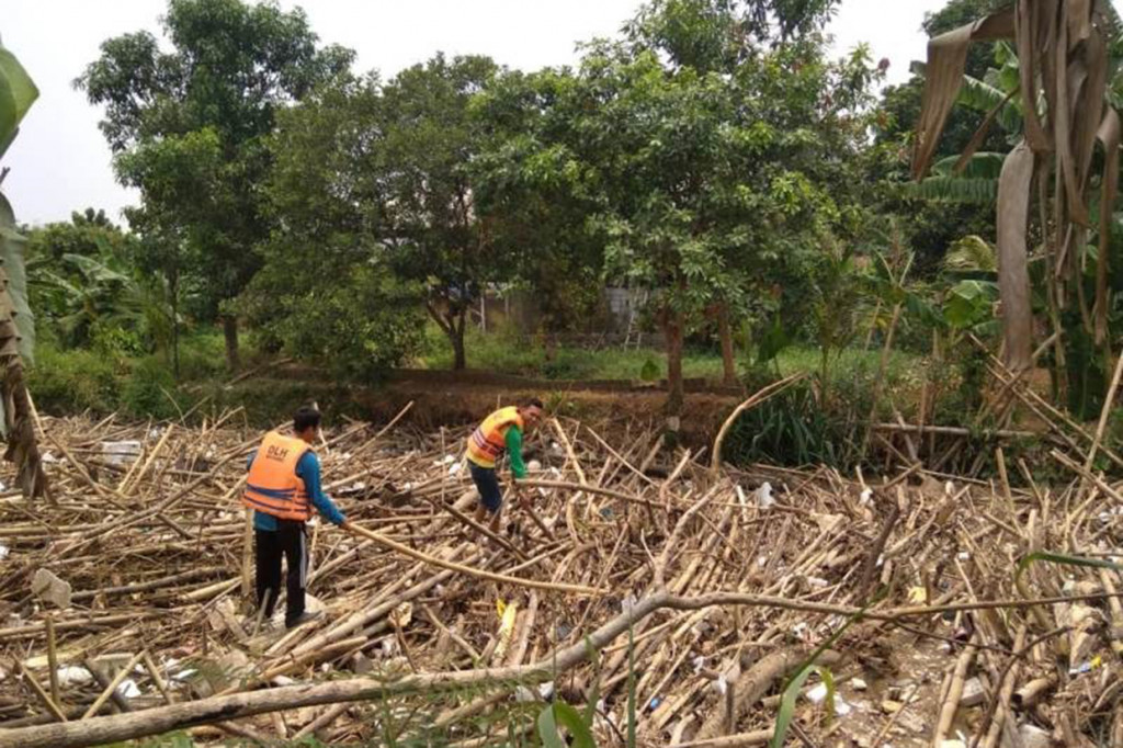 Sampah bambu yang menumpuk membuat lima perumahan yang dilintasi kali tersebut terancam banjir lantaran air tidak mengalir.