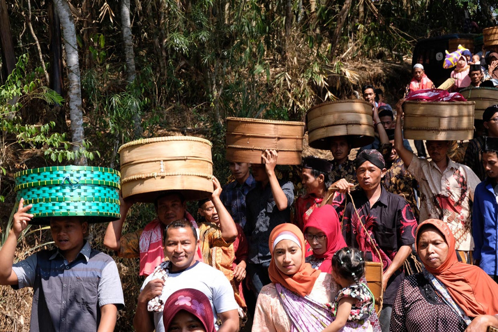 Sejumlah warga mengusung tenong berisi berbagai macam makanan saat tradisi Nyadran Ngropoh di komplek makam Desa Ngropoh, Kranggan, Temanggung, Jawa Tengah.