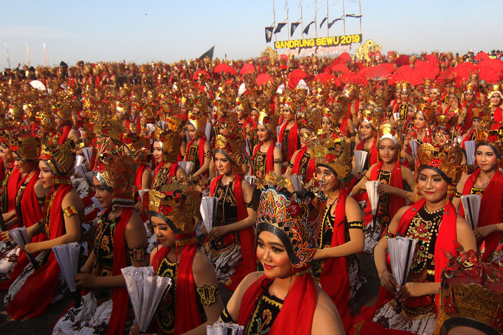 Berlatarkan Selat Bali, ribuan penari menarikan tari kolsal Gandrung Sewu di Pantai Boom, Banyuwangi, Jatim, Sabtu, 12 Oktober 2019. Penari Gandrung dalam balutan busana merah menyala menampilkan keindahan gerak tari.