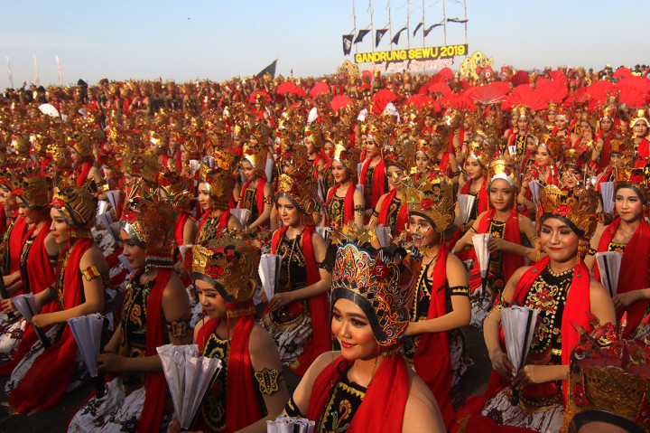 Berlatarkan Selat Bali, ribuan penari menarikan tari kolsal Gandrung Sewu di Pantai Boom, Banyuwangi, Jatim, Sabtu, 12 Oktober 2019. Penari Gandrung dalam balutan busana merah menyala menampilkan keindahan gerak tari.