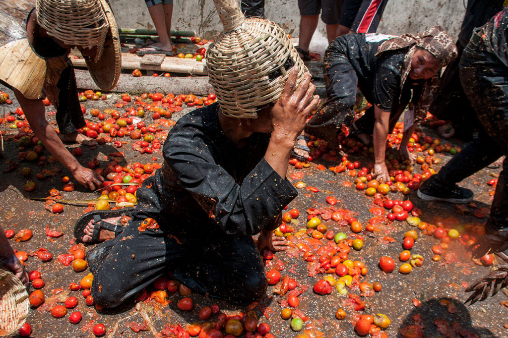 Warga saling melempar buah tomat pada tradisi Rempug Tarung Perang Tomat di Kampung Cikareumbi, Lembang, Kabupaten Bandung Barat, Jawa Barat, Minggu, 13 Oktober 2019.