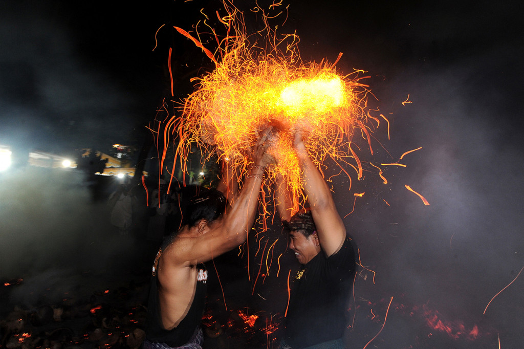 Sejumlah pemuda saling memukulkan api dari sabut kelapa saat mengikuti tradisi 