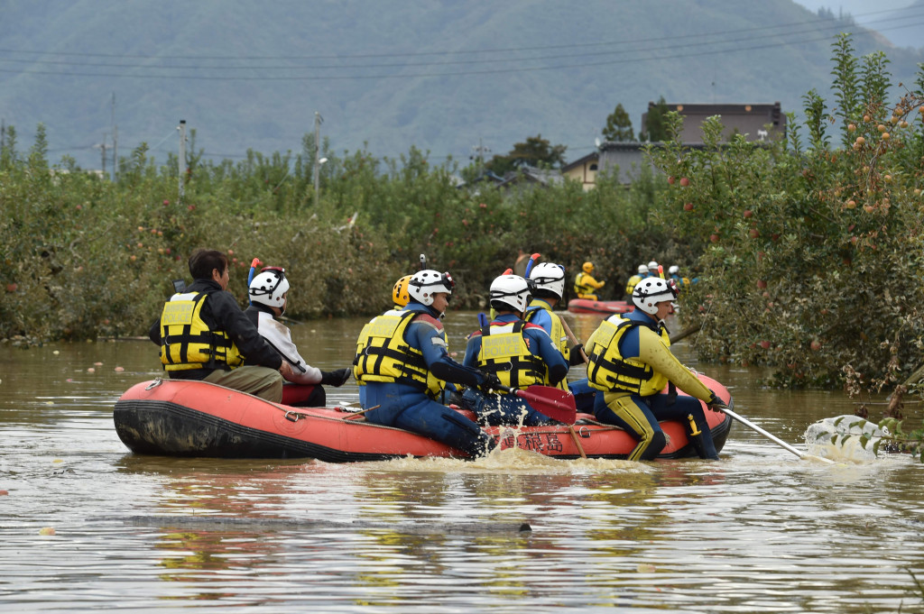 Petugas penyelamat membawa perahu karet dalam upaya mencari korban selamat yang terjebak banjir akibat topan Hagibis. AFP Photo/Kazuhiro Nogi
