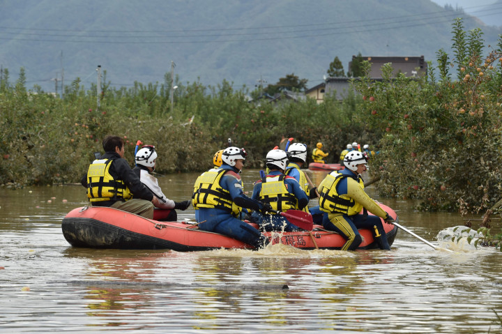 Petugas penyelamat membawa perahu karet dalam upaya mencari korban selamat yang terjebak banjir akibat topan Hagibis. AFP Photo/Kazuhiro Nogi
