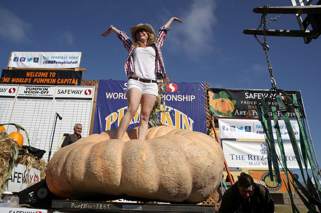 Cindy Tobeck dari Olympia, Washington, berdiri di atas labu seberat 1,736 pon dalam Safeway World Championship Pumpkin Weigh-Off di Half Moon Bay, California.