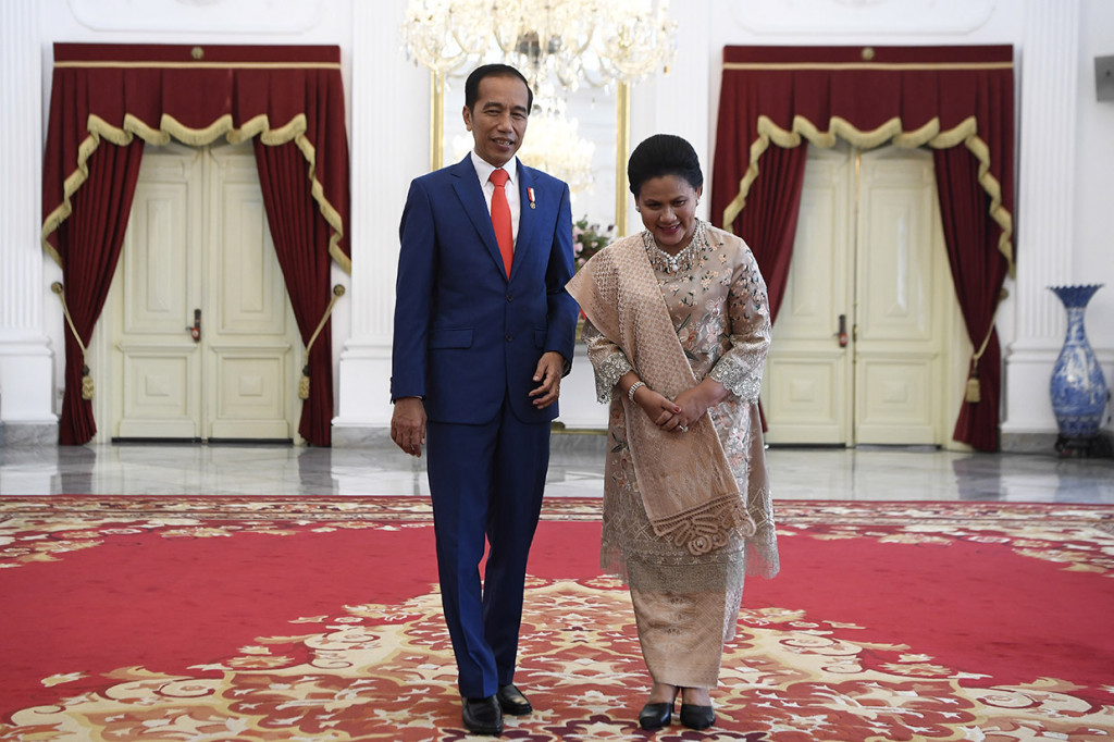 Jokowi tampil mengenakan setelan jas berwarna biru tua dipadu dengan dasi merah.