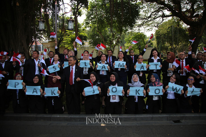 Pegawai Sekretariat Presiden membentangkan kertas bertuliskan 