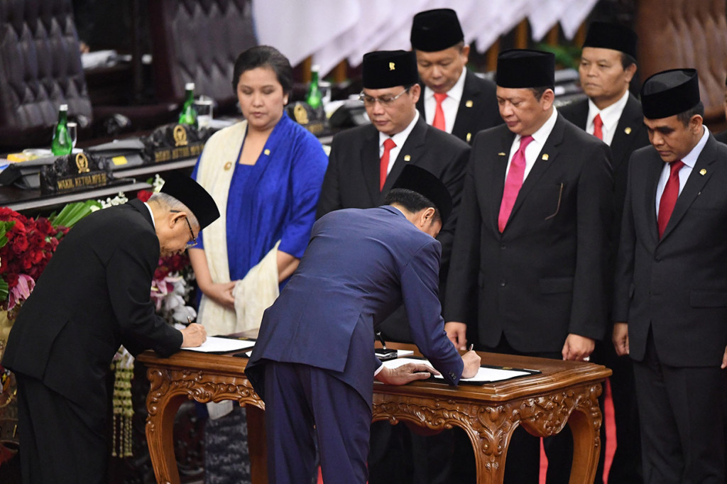 Presiden Joko Widodo (kedua kiri) dan Wapres Ma'ruf Amin membubuhkan tanda tangan disaksikan para pimpinan MPR saat upacara pelantikan presiden dan wakil presiden periode 2019-2024 di Gedung Nusantara, kompleks Parlemen, Senayan, Jakarta.