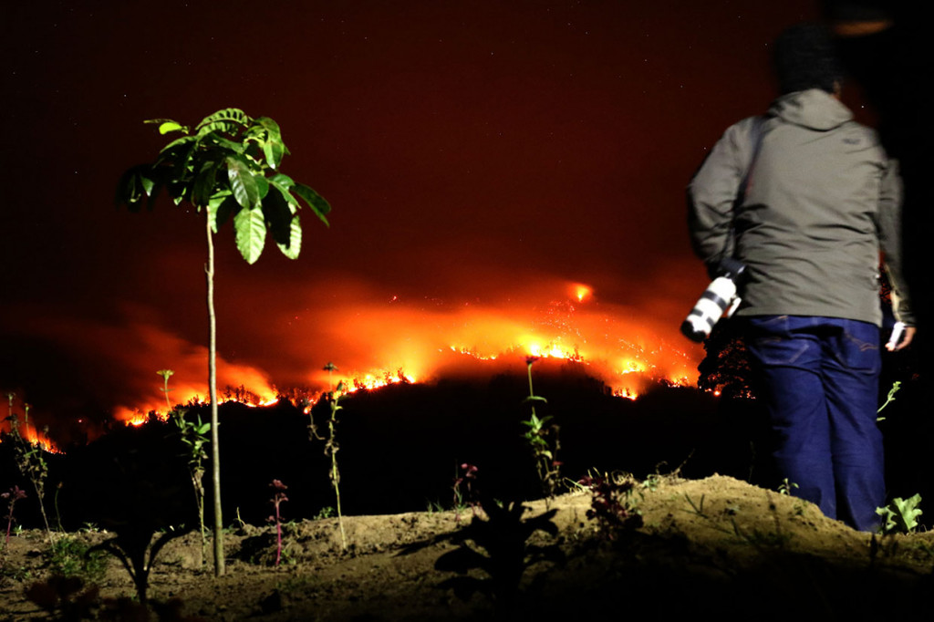 Kebakaran hutan Gunung Merapi Ungup-ungup terlihat dari Gantasan, Taman Sari, Banyuwangi, Jawa Timur, Senin, 21 Oktober 2019 malam. Tidak adanya akses jalan menuju cagar alam itu, membuat tim SAR kesulitan melakukan pemadaman. 