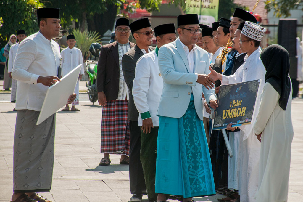Gubernur Jawa Barat Ridwan Kamil (ketiga kanan) memberikan hadiah umroh kepada perwakilan pondok pesantren dan DKM pada upacara Peringatan Hari Santri Nasional Tingkat Provinsi Jawa Barat 2019 di Lapangan Gasibu, Bandung, Jawa Barat. Pemerintah Jabar memberikan sejumlah bantuan motor listrik dan hadiah umroh bagi santri, pondok pesantren serta DKM se-Jawa Barat pada Peringatan Hari Santri Nasional 2019 yang bertema 'Santri Indonesia Untuk Perdamaian Dunia'. Antara Foto/Novrian Arbi