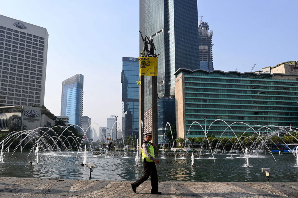 Aktivis Greenpeace melakukan aksi protes secara unik dengan memasang spanduk raksasa bertuliskan 'Orang Baik Pilih Energi Baik' di Patung Selamat Datang, Bundaran HI, Jakarta Pusat, Rabu, 23 Oktober 2019.