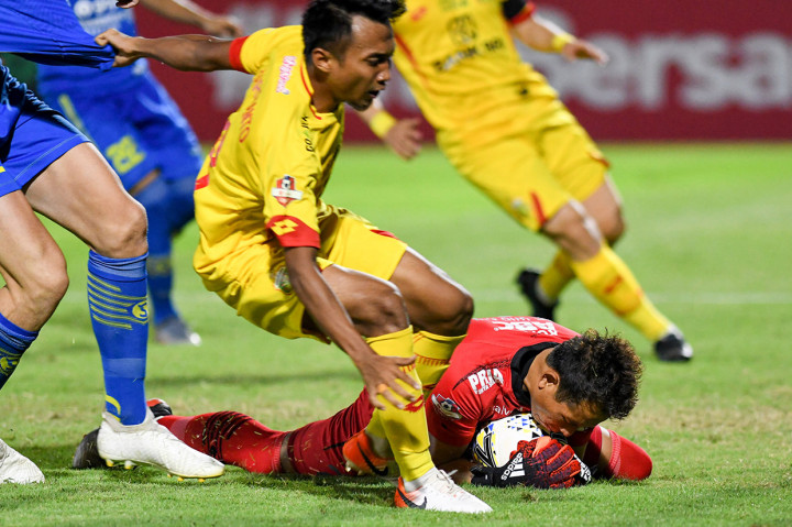 Penjaga gawang Persib Bandung I Made Wirawan (kanan) berusaha mengamankan bola dari pesepak bola Muhamad Hargianto (kiri) dalam lanjutan Liga 1 Indonesia di Stadion PTIK, Jakarta. Pertandingan berakhir imbang 0-0.