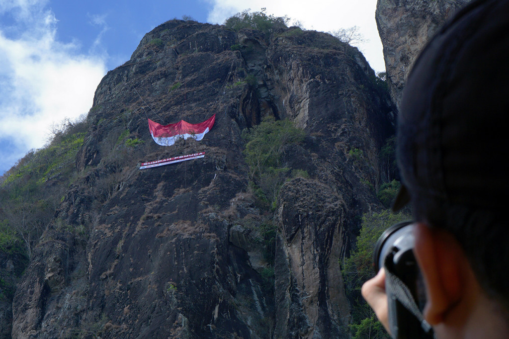 Proses pengibaran bendera merah putih raksasa berukurasan berukuran 30 x 20 meter dengan ketinggian sekitar 380 meter dari permukaan tanah di tebing Gunung Spikul, Trenggalek, Jawa Timur, Senin. Antara Foto/Destyan Sujarwoko