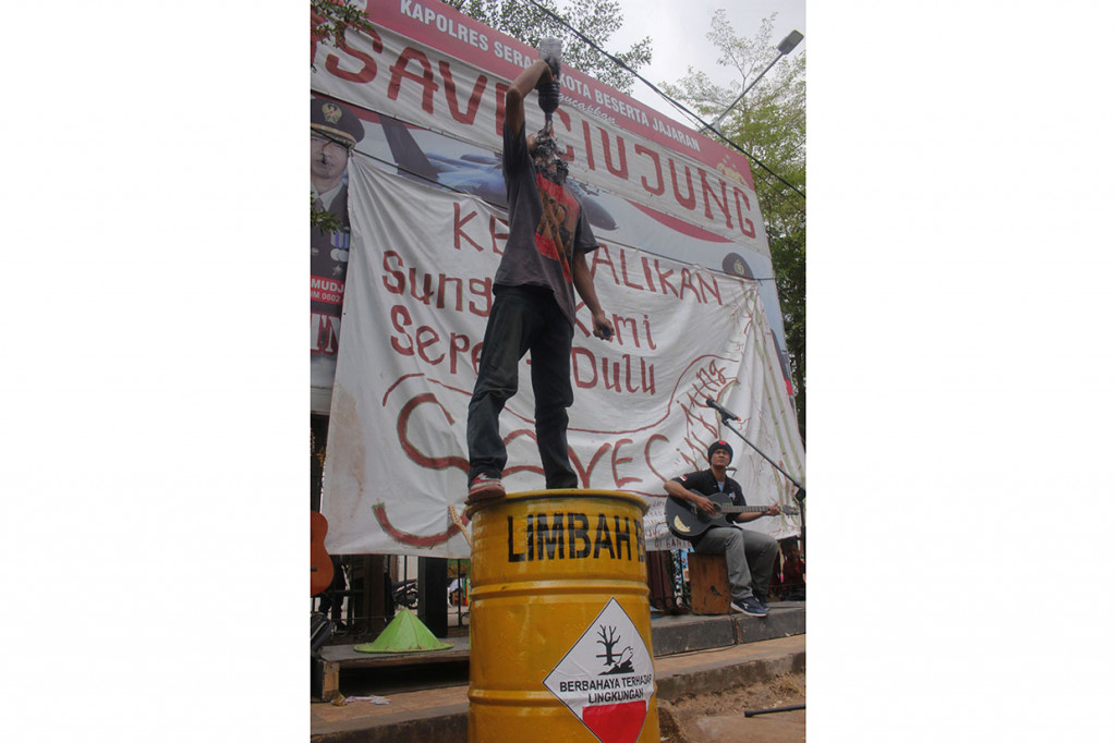 Pengunjuk rasa yang tergabung dalam Forum Mahasiswa Pecinta Alam (MAPALA) Banten menggelar aksi teatrikal dengan minum air limbah di Alun-alun Serang.
