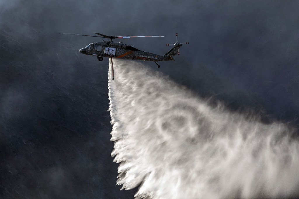 Sebuah helikopter melakukan water bombing untuk memadamkan api yang berkobar di Los Angeles, California, Senin, 28 Oktober 2019 waktu setempat.