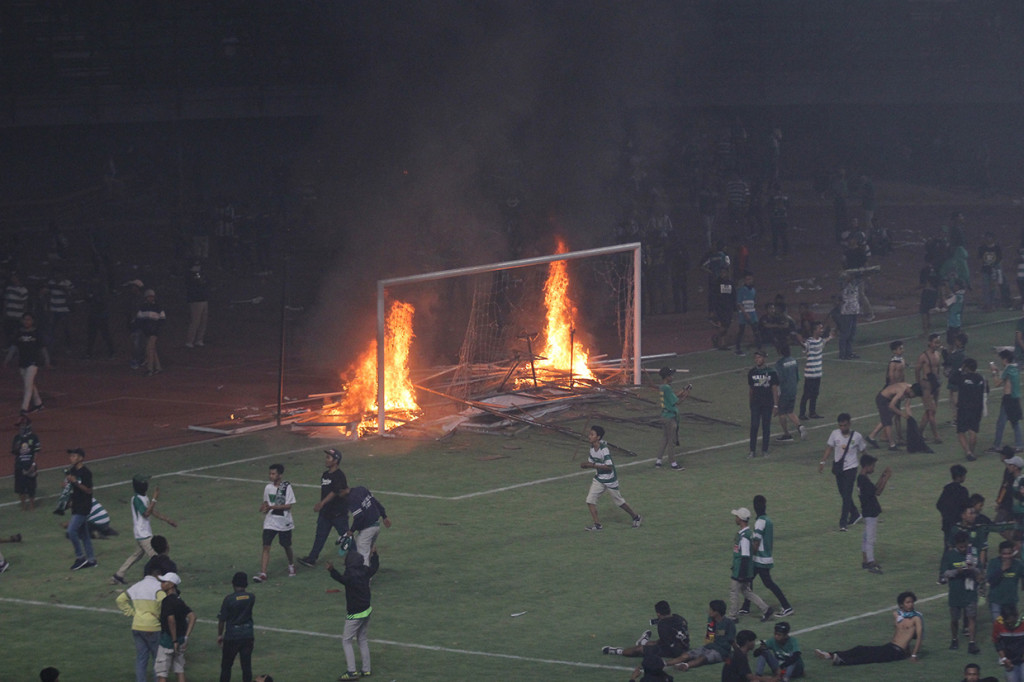 Suporter Persebaya membakar papan sponsor usai pertandingan Liga 1 2019 antara Persebaya dan PSS Sleman di Stadion Gelora Bung Tomo, Surabaya, Jawa Timur.