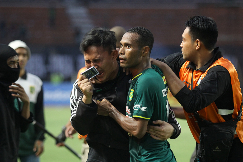 Pesepak bola Persebaya Ruben Karel Sanadi (kedua kanan) mencoba menenangkan seorang suporter yang kecewa usai pertandingan Persebaya melawan PSS Sleman pada Liga 1 2019 di Stadion Gelora Bung Tomo, Surabaya, Jawa Timur.
