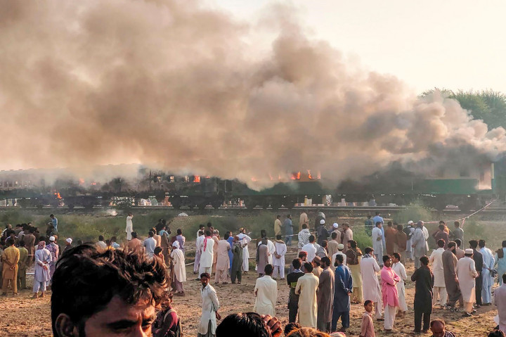 Tiga rangkaian gerbong kereta api penumpang dilalap api di dekat Rahim Yar Khan, Provinsi Punjab, Pakistan, Kamis, 31 Oktober 2019.