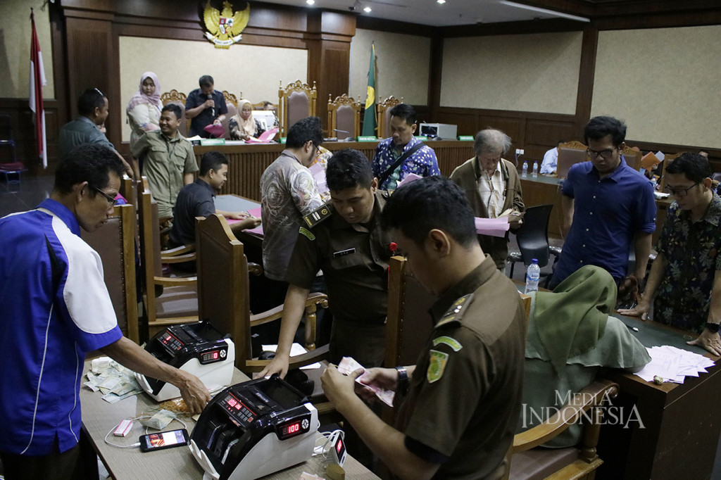 Pembayaran denda dilakukan langsung di ruang pengadilan dengan uang tunai.
