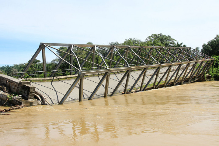 Jembatan rangka baja yang sejak setahun terakhir mengalami kerusakan dan kemiringan tersebut akhirnya ambruk pada Kamis, 31 Oktober 2019 siang, akibat beton penahan jembatan terkikis air.