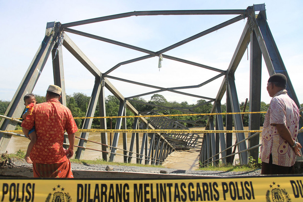Warga melihat konstruksi jembatan rangka baja penghubung Kecamatan Kaway XVI dan Kecamatan Pante Ceureumen yang ambruk di Desa Sawang Teubee, Kaway XVI, Aceh Barat, Aceh, Jumat, 1 November 2019.
