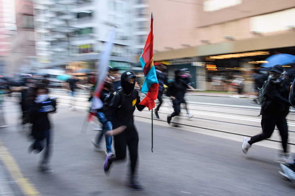 Aksi kejar-kejaran antara demonstran dan polisi anti huru hara berlanjut hingga dini hari Minggu pagi usai pembubaran dengan tembakan gas air mata. AFP Photo/Anthony Wallace