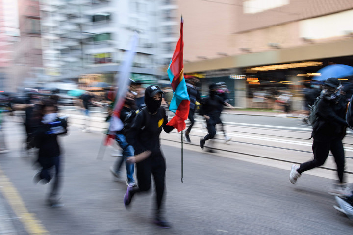 Aksi kejar-kejaran antara demonstran dan polisi anti huru hara berlanjut hingga dini hari Minggu pagi usai pembubaran dengan tembakan gas air mata. AFP Photo/Anthony Wallace