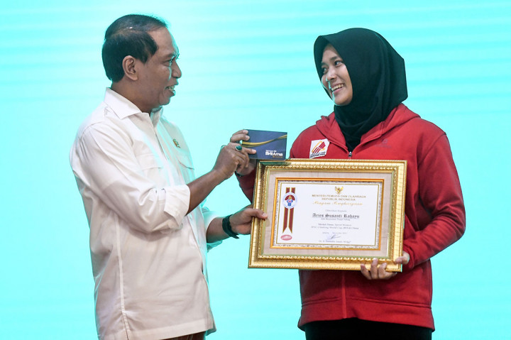 Menpora Zainudin Amali menyerahkan buku tabungan dan piagam penghargaan kepada atlet panjat tebing putri Indonesia Aries Susanti Rahayu saat penyerahan bonus atlet juara dunia di Jakarta, Selasa, 5 November 2019.